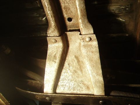 1978 Ford Bronco - Close-up view of a heavily rusted metal bracket, likely from the undercarriage of a vehicle.