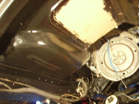 1978 Ford Bronco - Underside view of vehicle components, including the engine and transmission bell housing, with visible fuel lines and wiring.