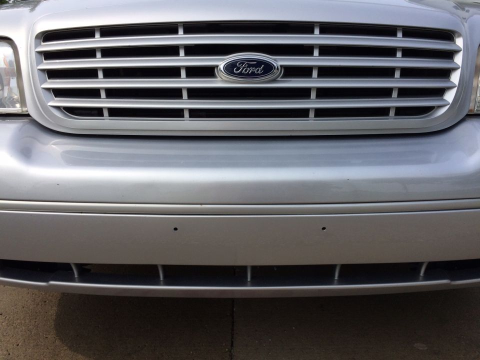 Silver Ford Crown Victoria front grille and bumper with Ford logo and parking sensors