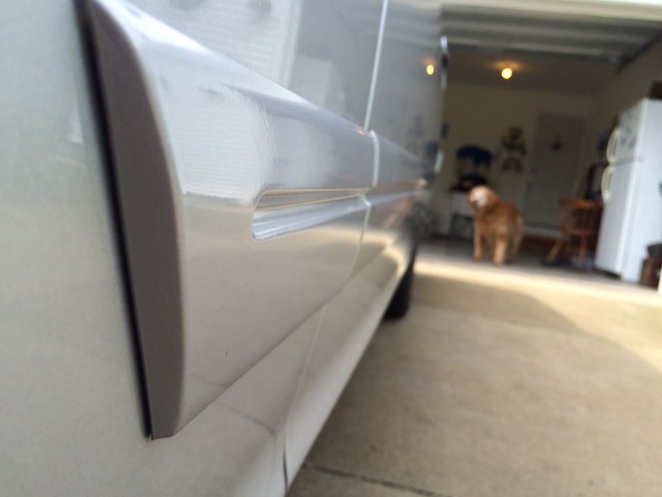 Silver vehicle body trim, garage interior with dog in background