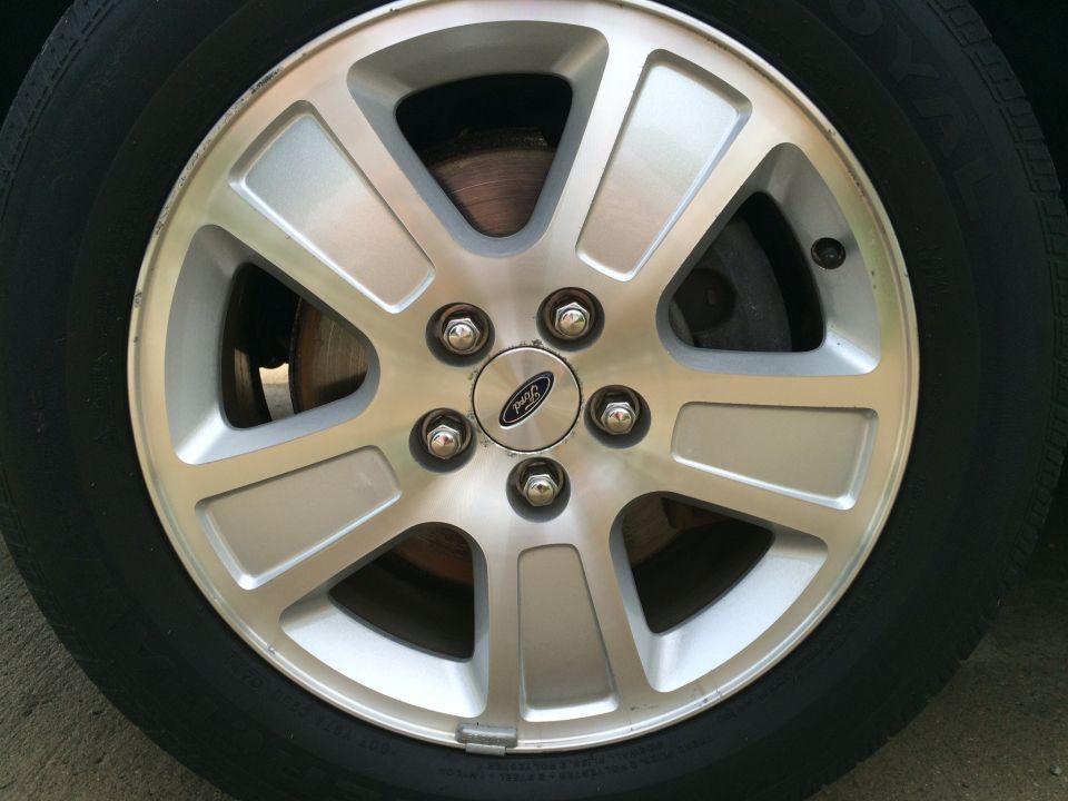 Silver Ford alloy wheel with Ford logo, showing brake rotor.