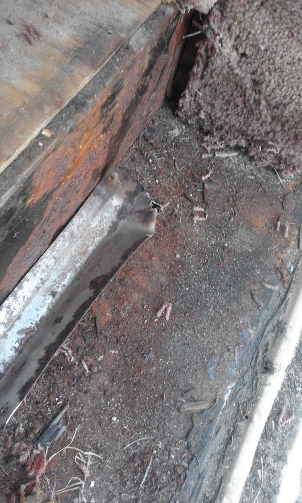 Rusted metal and insulation debris under a vehicle.