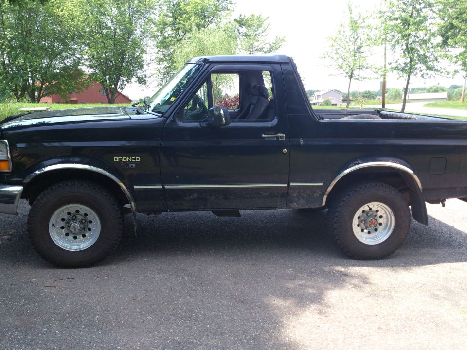 Side view of a black 1995 Ford Bronco with chrome trim and 5.8 badging.
