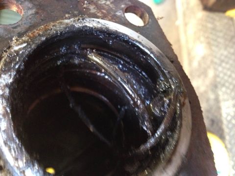1979 Ford Bronco - A close-up view of a heavily soiled and corroded metal component, likely a part of an engine or transmission, with visible grease and grime.
