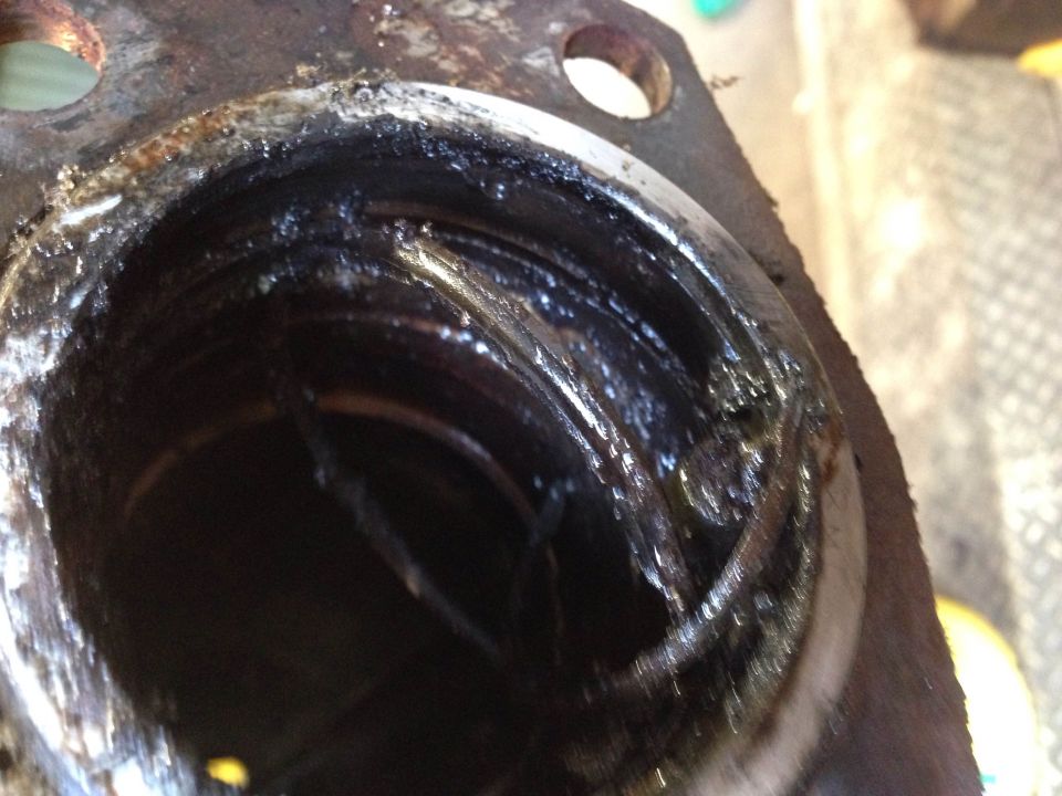 Close-up of a dirty, corroded metal part with grease and grime.