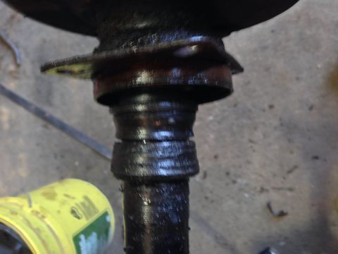 1979 Ford Bronco - A close-up, low-angle shot shows a heavily greased metal shaft with several distinct grooves. A yellow container with green and white label…