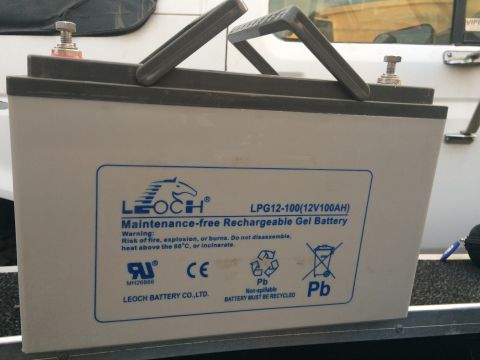 1997 Dodge 3500 - A close-up shot of a Leoch LPG12-100 (12V100AH) maintenance-free rechargeable gel battery with a blue and white label. The battery has a gr…