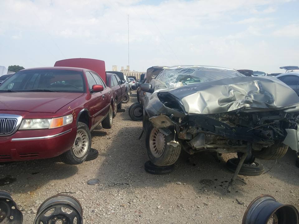 Wrecked vehicles in a salvage yard, front collision damage