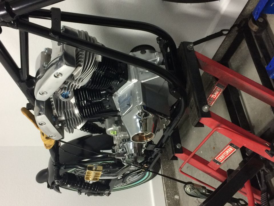 Motorcycle engine with chrome parts on a red and black Craftsman lift.
