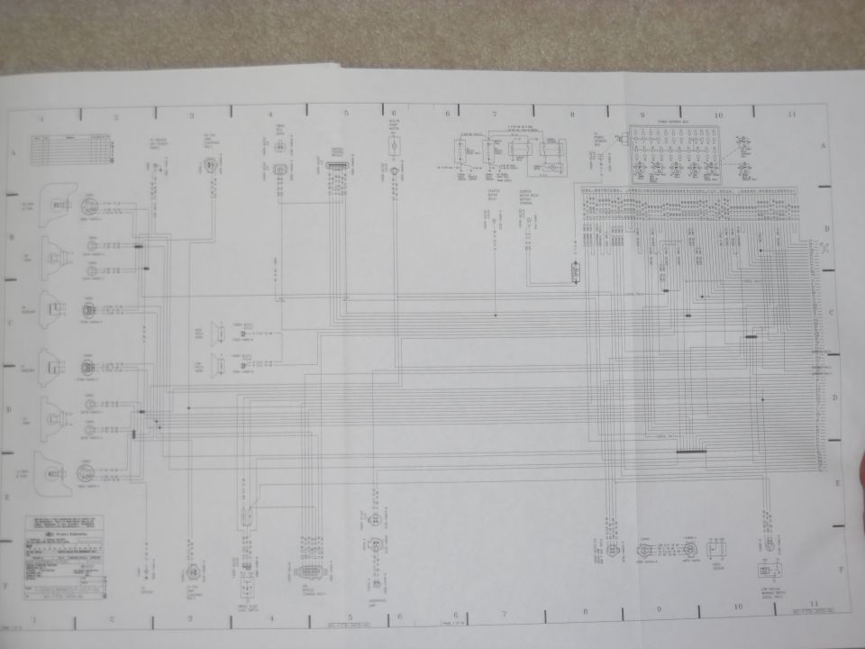 Photocopied automotive wiring diagram page with grid, fuse box and connectors, on carpet