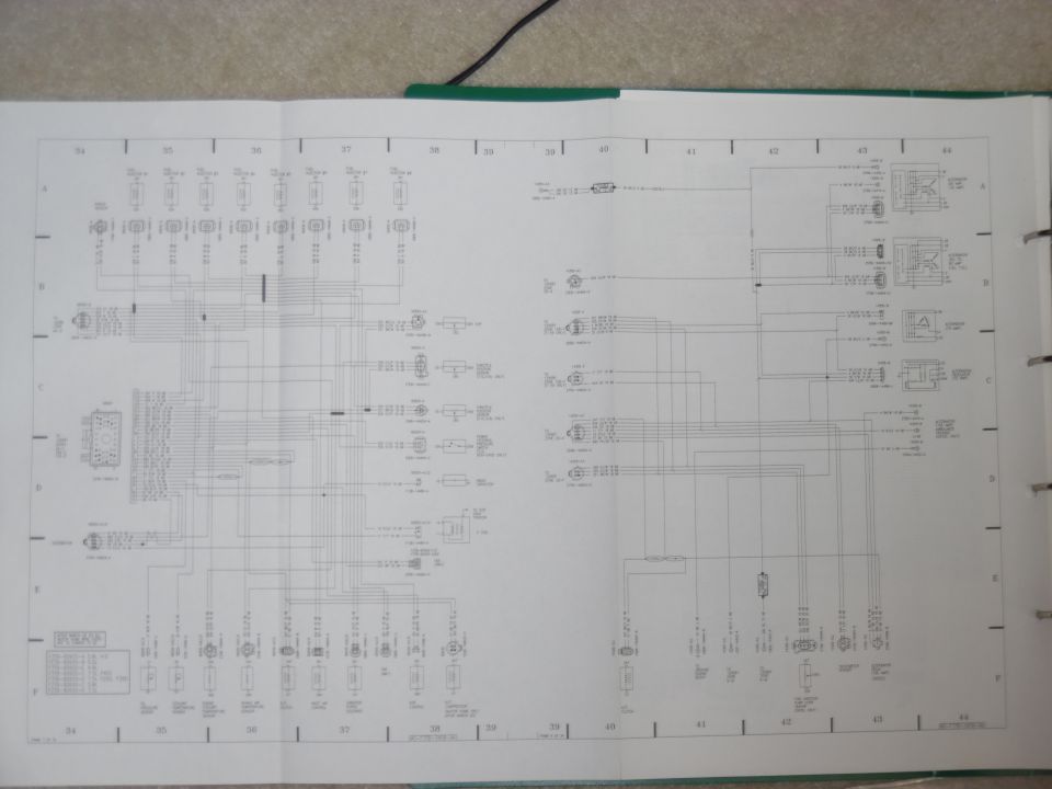 Open vehicle service manual showing a two-page electrical wiring diagram