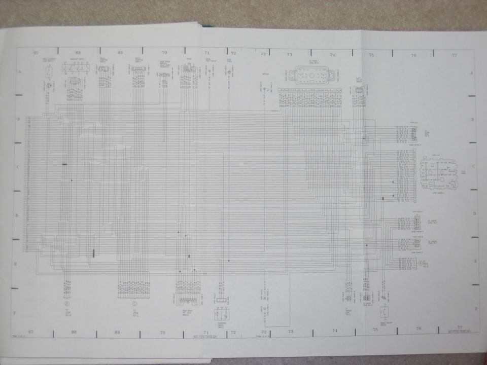 Fold-out factory wiring diagram spread, grid sections 67-77, with multi-pin connectors and circuit runs
