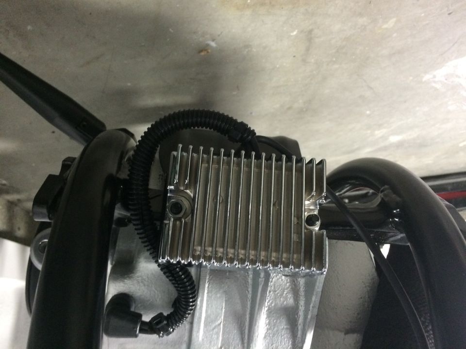 Silver finned motorcycle part with black wiring conduit.