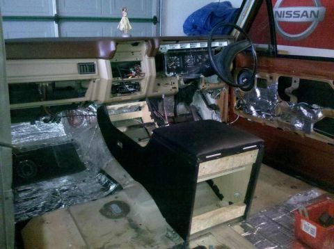 1982 Ford Bronco - Interior of a vehicle undergoing renovation, showing exposed components and sound dampening materials.