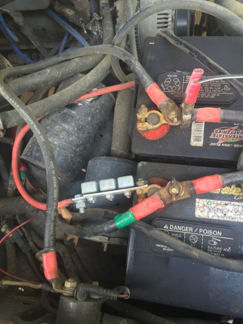 1993 Ford Bronco - Close-up view of a vehicle's battery wiring and terminals, showing multiple cables and a fuse block.
