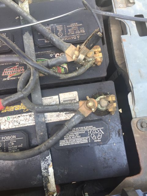 1993 Ford Bronco - Close-up view of two car batteries, showing their terminals and wiring.