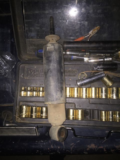1993 Ford Bronco - A shock absorber and a set of sockets are laid out, suggesting a repair or maintenance task.