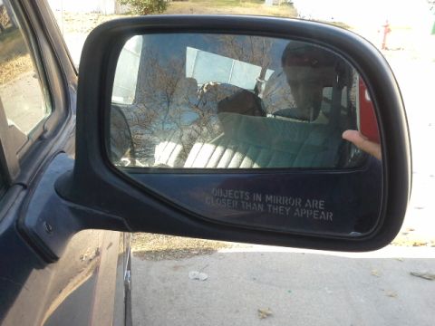 1993 Ford Bronco - Reflection in the side mirror shows the interior and a person holding a phone.