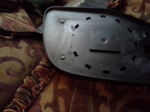1993 Ford Bronco - The reverse side of a car's side mirror assembly, showing mounting points and internal structure.