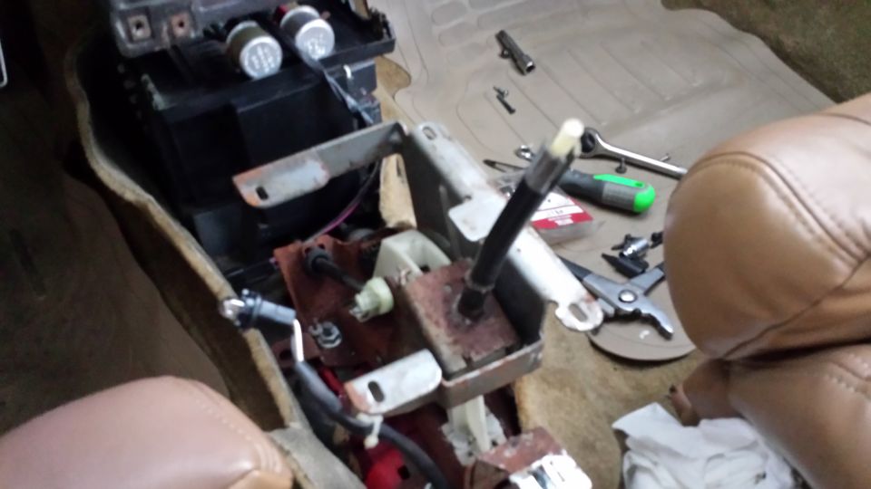 car interior center console disassembled with tools nearby