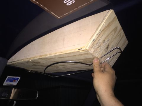 1993 Ford Bronco - A custom wooden storage box is being held up inside the vehicle's cabin, likely attached to the headliner. The box has metal brackets and a…