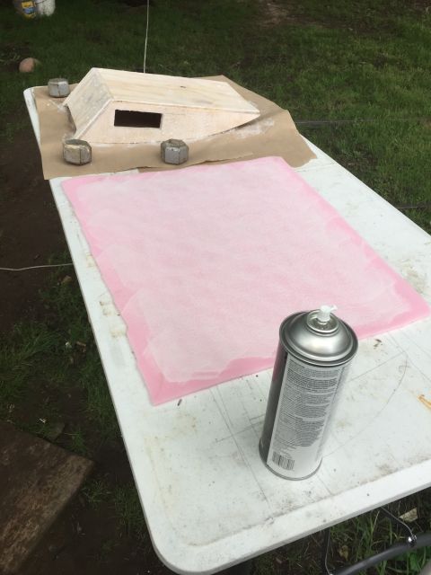 1993 Ford Bronco - A wooden structure with a rectangular opening sits on a table covered with brown paper. A can of spray paint and a pink mat are also on the…