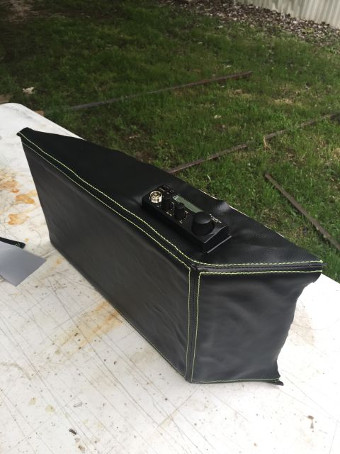 1993 Ford Bronco - A black leather-covered box with neon green stitching sits on a white table outdoors. A small electronic device with knobs and a screen is…