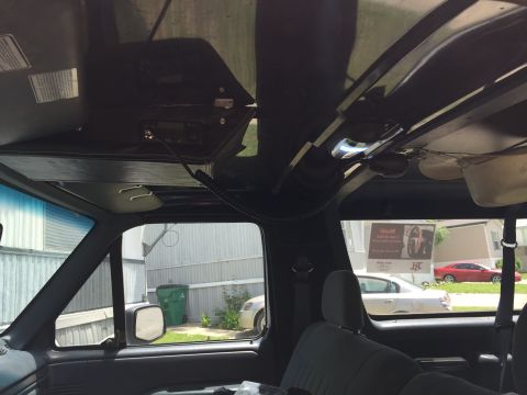 1993 Ford Bronco - Interior view of a 1993 Ford Bronco, looking up at the overhead console with a CB radio mounted. The view looks out the front windshield an…