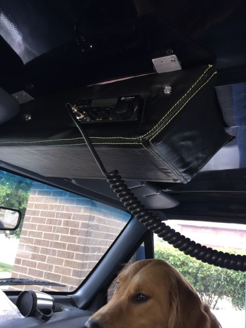 1993 Ford Bronco - Interior view of a vehicle showing a CB radio mounted above the windshield and a golden retriever in the driver's seat.