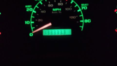 1993 Ford Bronco - A close-up of a vehicle's dashboard shows a glowing green speedometer with a needle pointing between 0 and 10 MPH. A digital odometer displ…