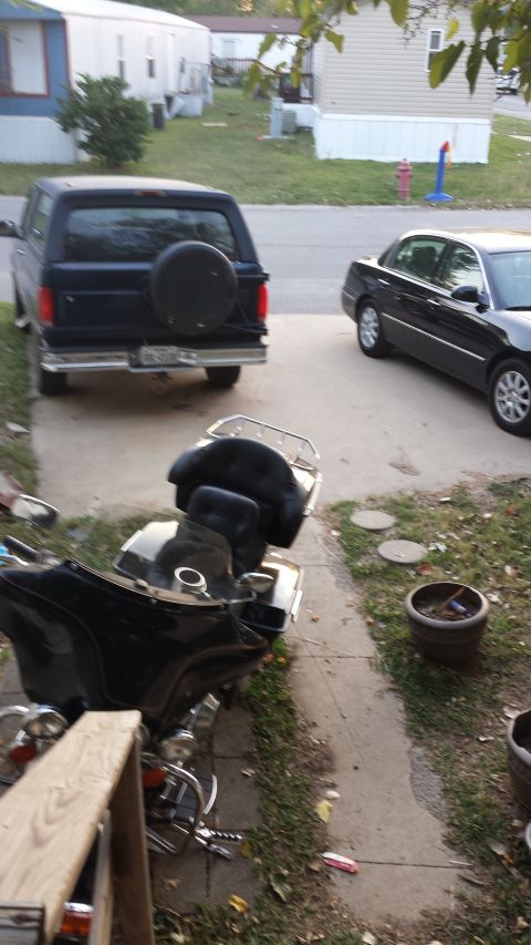 1993 Ford Bronco - A black Ford Bronco with a spare tire mounted on the rear is parked on a concrete driveway. A black sedan is parked on the street next to t…