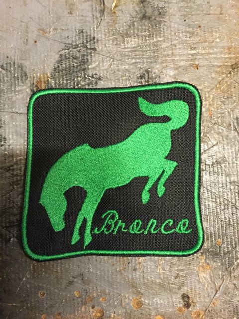 1993 Ford Bronco - A black patch with a green embroidered silhouette of a bucking horse and the word "Bronco" below it. The patch has a green border and is pl…