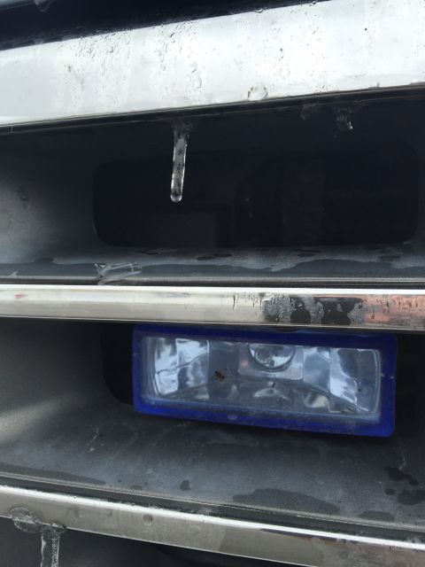 1993 Ford Bronco - A close-up view of a vehicle's front grille area shows a single icicle hanging from the chrome trim above a blue-trimmed fog light assembly.