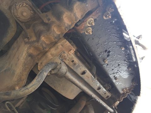 1993 Ford Bronco - This is an underside view of a vehicle's suspension system, showing a sway bar, mounting brackets, and frame components. The parts are heav…