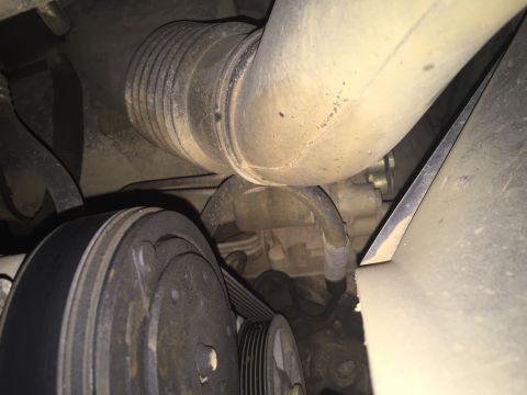 1993 Ford Bronco - A close-up view of the engine bay of a 1993 Ford Bronco, showing the serpentine belt, pulley system, and a large air intake hose.