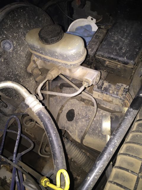1993 Ford Bronco - This image shows a close-up view of the engine bay of a 1993 Ford Bronco, focusing on the brake master cylinder and surrounding components.…