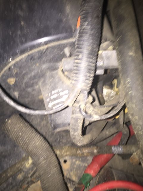 1993 Ford Bronco - A close-up view of automotive wiring and components, possibly from a 1993 Ford Bronco, showing a black corrugated conduit, red insulated ca…