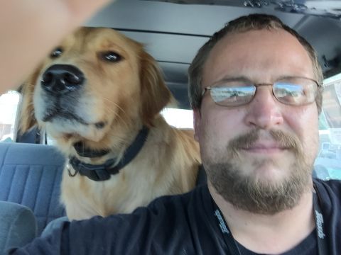 1993 Ford Bronco - A man and a golden retriever dog are in the interior of a vehicle, possibly a 1993 Ford Bronco, with the dog in the passenger seat and the…