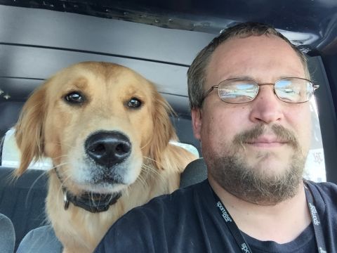 1993 Ford Bronco - A man and a golden retriever dog are in the front seats of a vehicle.
