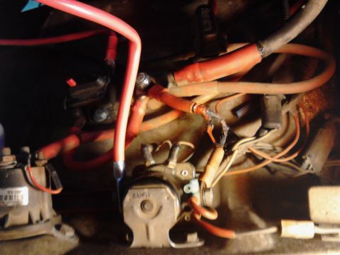 1973 Ford F-250 - A close-up view of a vehicle's electrical system shows several thick red and orange wires connected to various components, including what a…