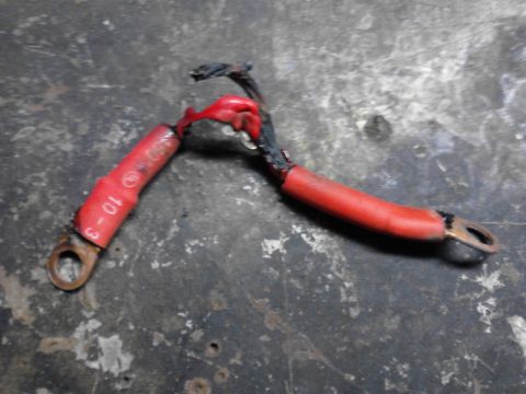 1973 Ford F-250 - A close-up view of two damaged red battery cables with ring terminals. Text on one cable reads "10-3".