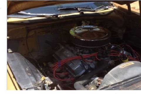 1973 Ford Ranchero - The engine bay of a classic Ford Ranchero, showcasing a V8 engine with a chrome air cleaner and red spark plug wires. The vehicle appears t…