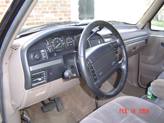 Tan dashboard, gauge cluster and leather-wrapped steering wheel inside an older Ford truck