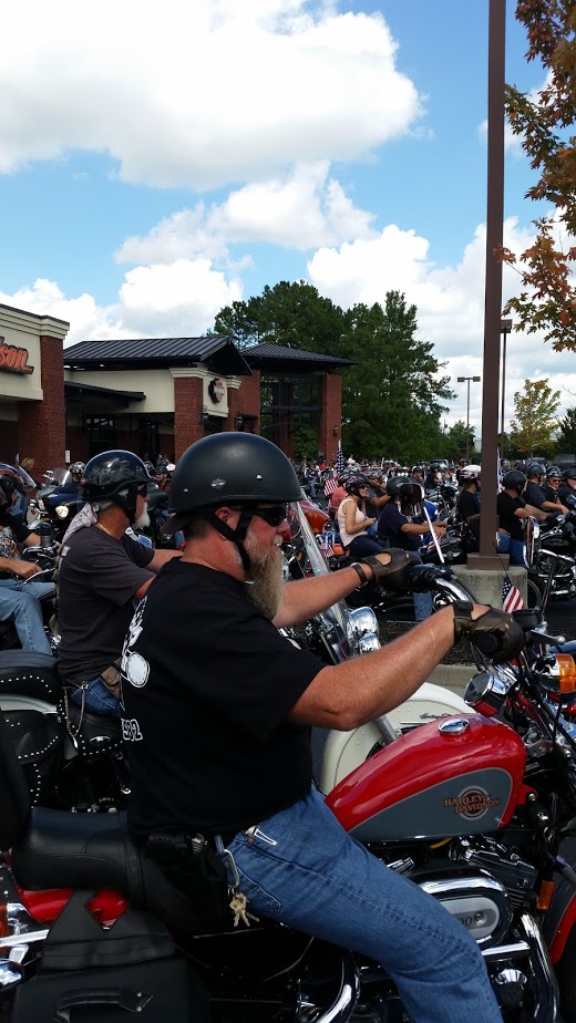 Man in black helmet and sunglasses riding a Harley-Davidson motorcycle.