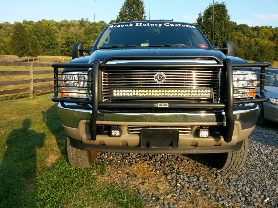 Black Ford Excursion with bull bar and LED light bar, front view.