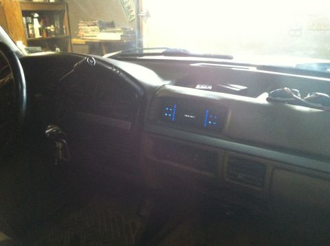 2004 Ford F-250 - Interior view of a truck dashboard with a digital display showing blue illuminated segments. A steering wheel and keys in the ignition are…
