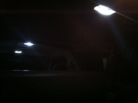 2004 Ford F-250 - The interior of a vehicle at night, with the overhead dome lights illuminated. The view is looking towards the rear of the cabin.