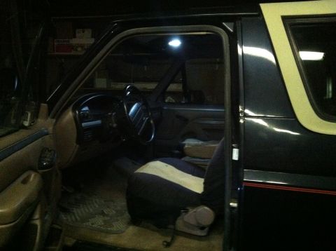 2004 Ford F-250 - The interior of a dark-colored truck is shown with the driver's door open. Visible elements include the steering wheel, dashboard, driver's…