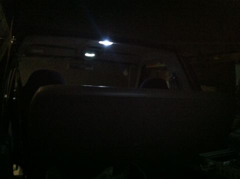 2004 Ford F-250 - Interior view of a dark-colored vehicle, likely a truck, with three LED dome lights illuminated on the headliner. The rear seat back is vis…