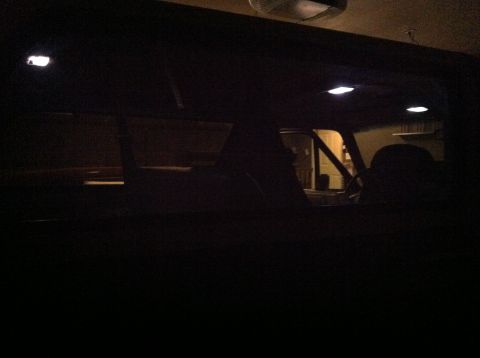 2004 Ford F-250 - The interior of a dark vehicle is visible, with interior lights illuminated. The view looks through the windshield and side windows into wh…